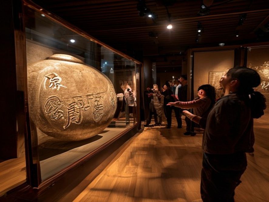 博物馆里人们围观带有奇怪纹饰的古代青铜器